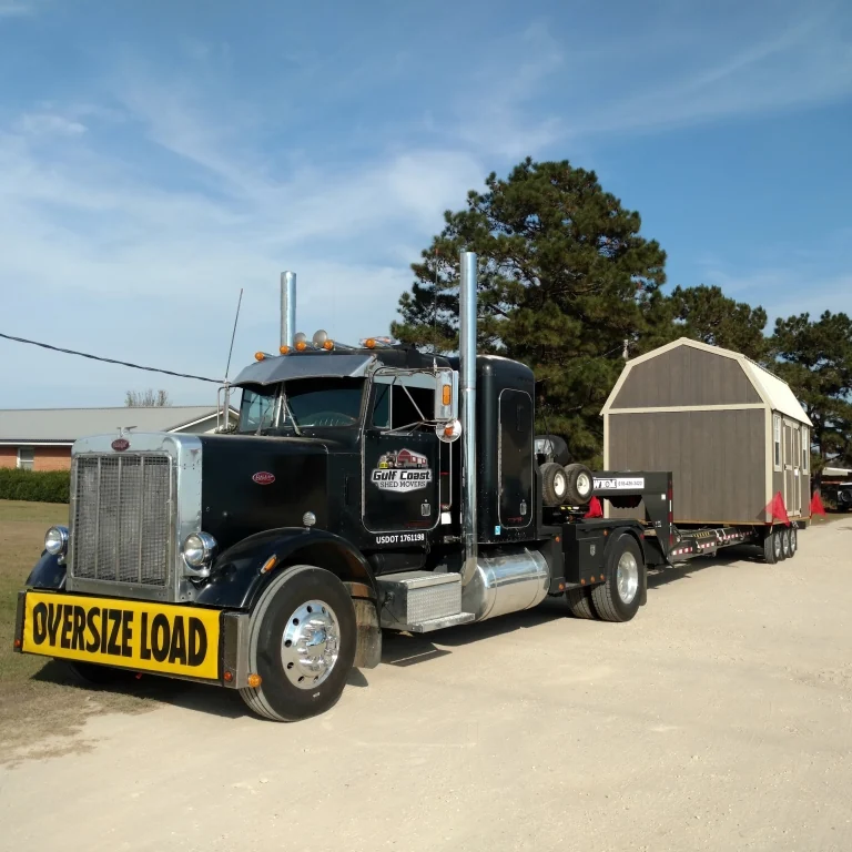 Gulf Coast shed delivery truck and trailer carrying a portable building