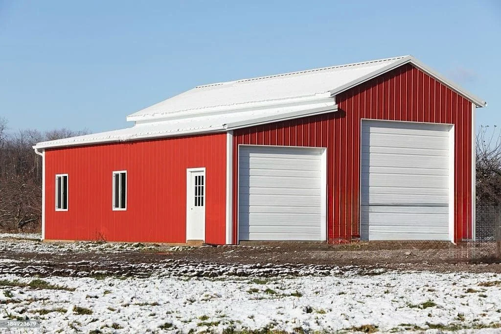 Red enclosed metal garage with two white roll-up doors